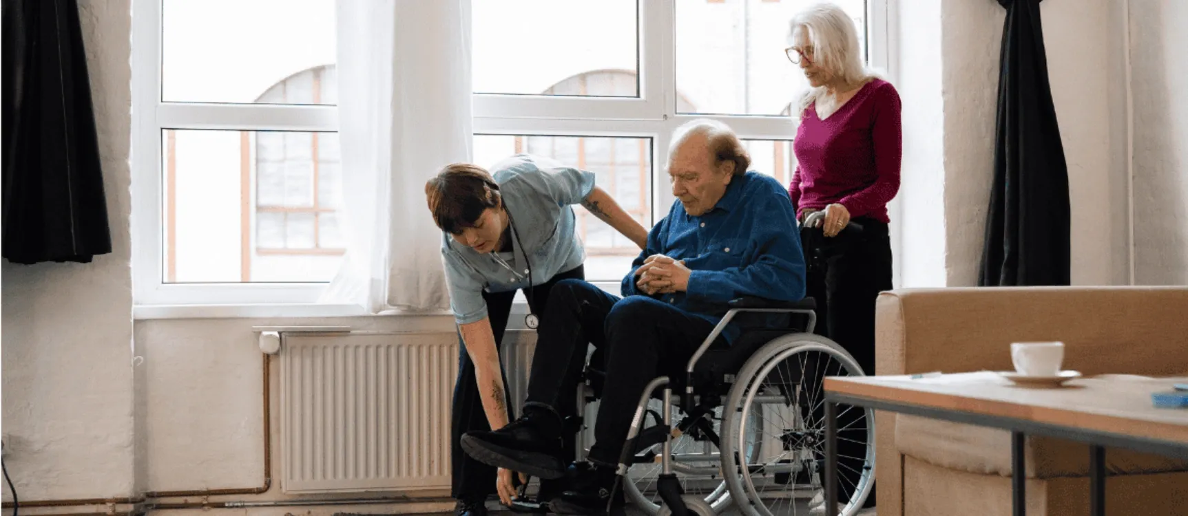 Altenpflegerin hilft Patient im Rollstuhl