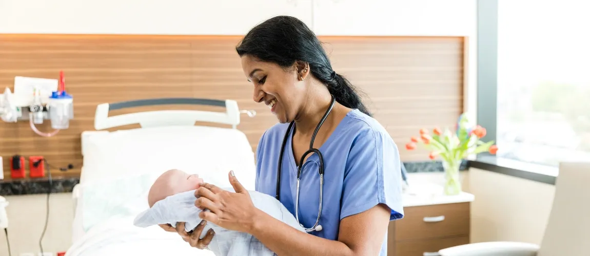 Hebamme hält Baby in den Händen