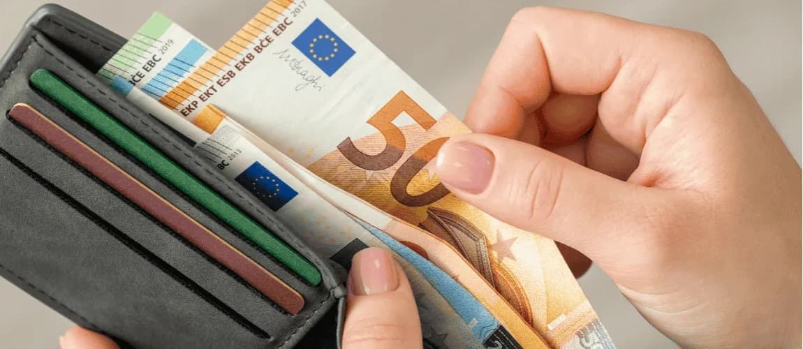 Hand nimmt 50 Euroschein auf dem Geldbeutel