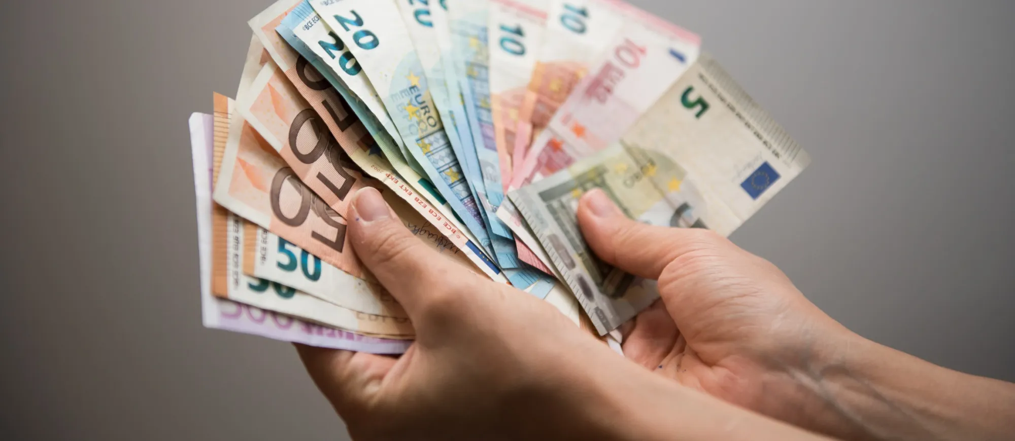 Hand hält aufgefächerte Euroscheine 
