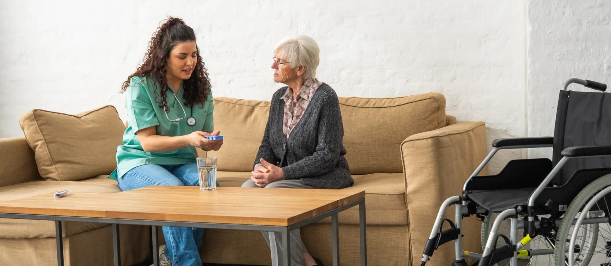 Pflegekraft gibt Patientin ihre Tabletten