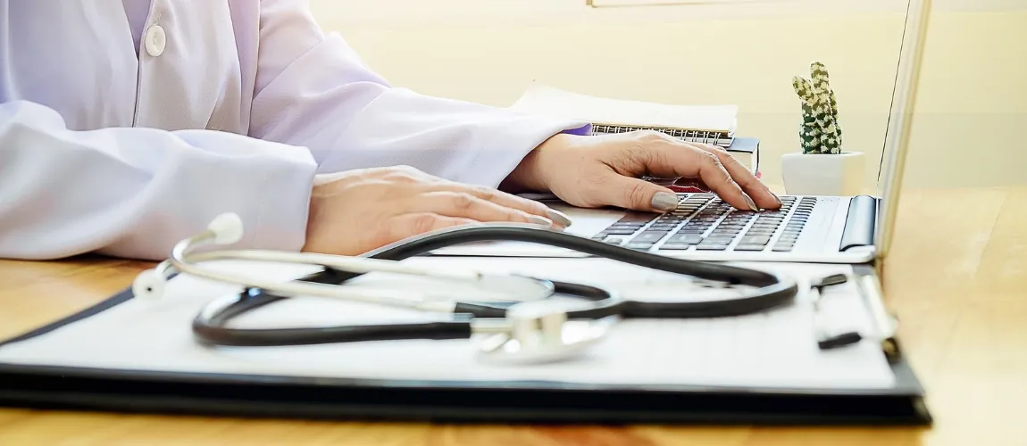 Frau (Heimleitung/Einrichtungsleitung) arbeitet an einem Laptop. 