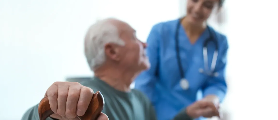 Altenpflegerin hilft Patient - TVöD-Pflege Entgeltgruppe 6