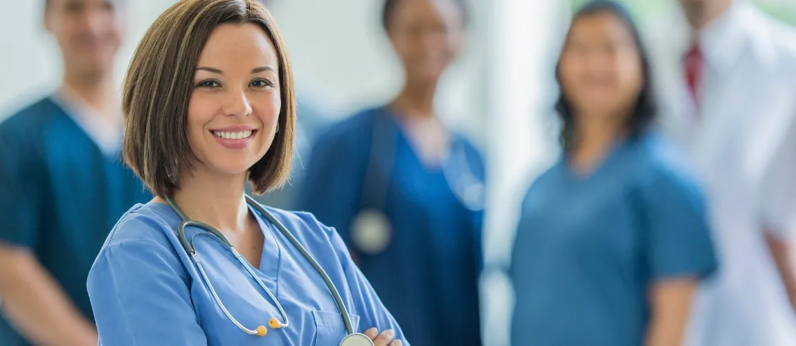 Eine Pflegekraft mit Entgeltsstufe E6 vor Kollegen. 