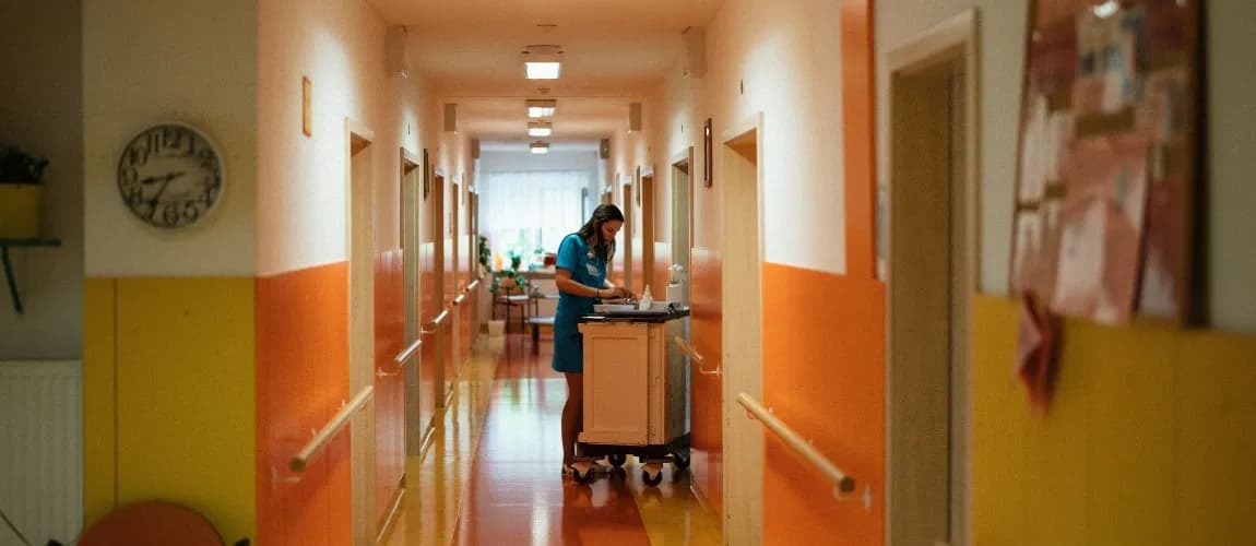 Eine Pflegeperson dokumentiert im Krankenhausflur. 