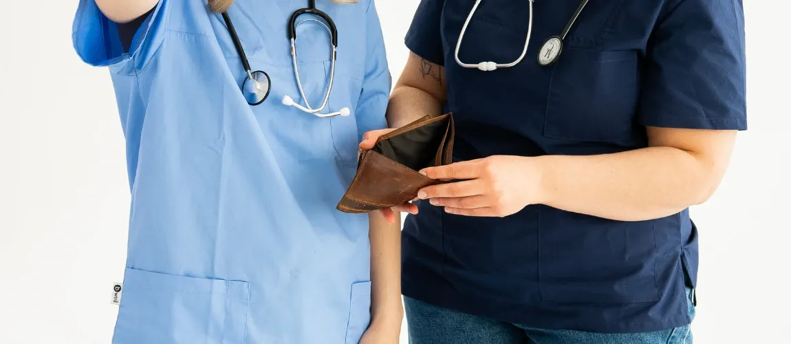 Zwei Pflegekräfte halten einen leeren Geldbeutel in den Händen.