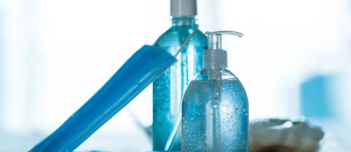 Desinfektionsmittel und Maske in Nahaufnahme.