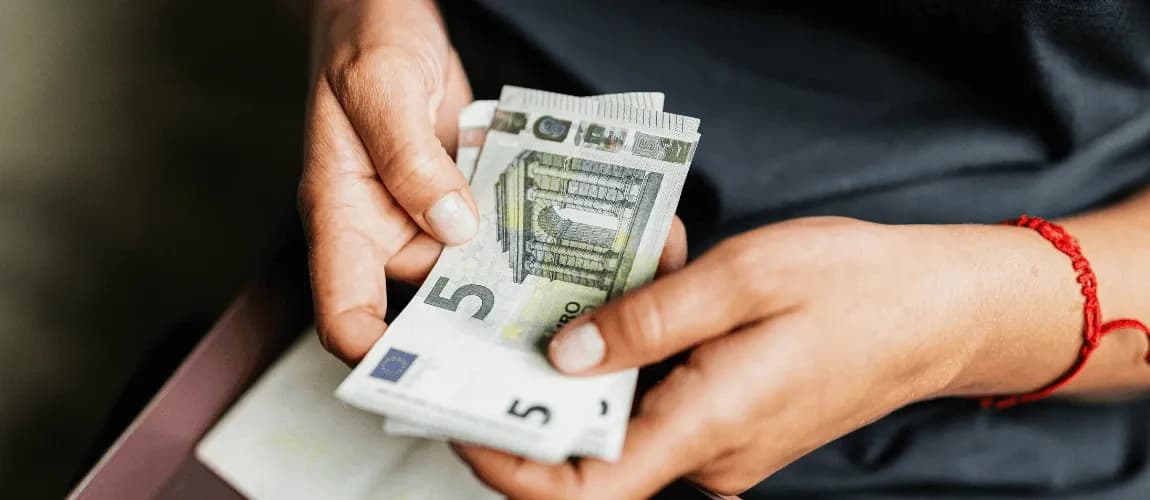 Frau hält 5 Euroscheine in der Hand.