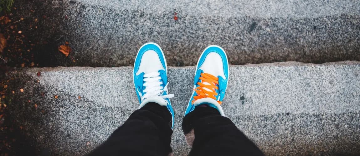 Blick von oben auf Beine und Schuhe.