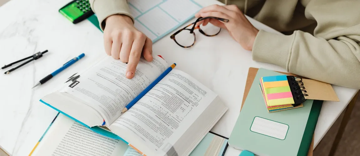 Eine Person zeigt mit dem Finger auf eine Stelle im Buch.
