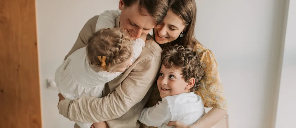 Eine Familie liegt sich in den Armen.
