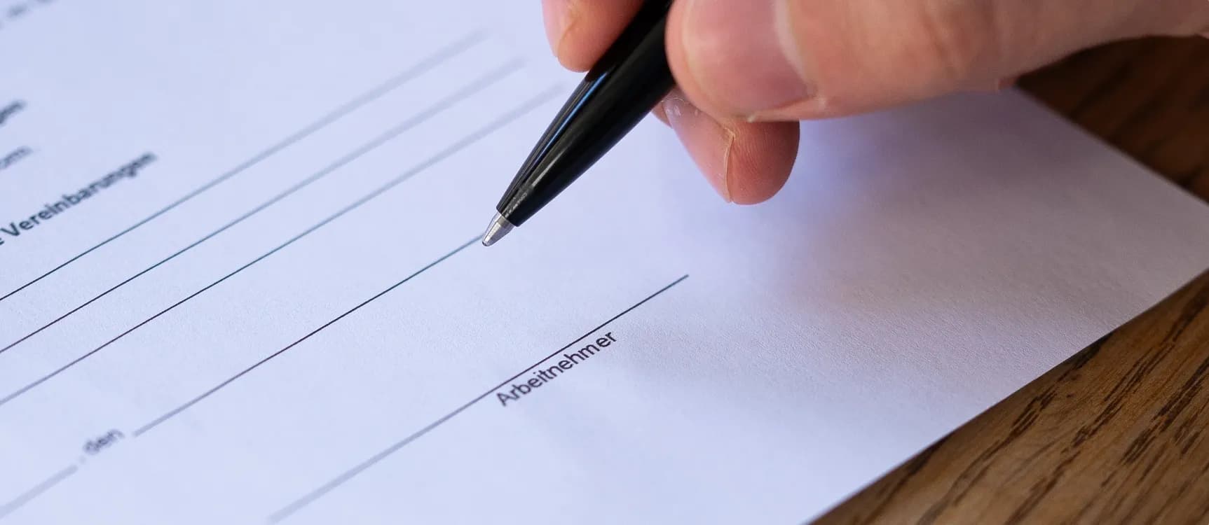 Mann unterschreibt Vertrag in der Pflege nach TVöD