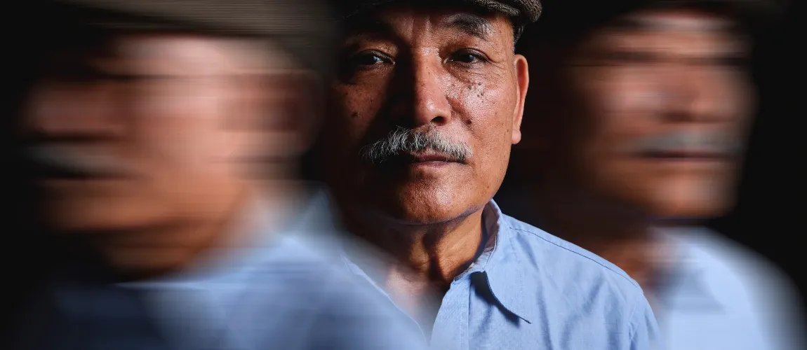 Ein Mann blickt frontal in die Kamera, daneben sind zwei verzerrte Bilder von ihm.